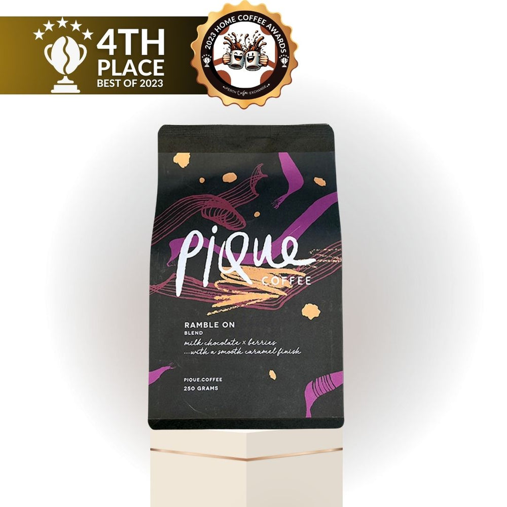 Perth package of Pique Coffee bearing a "4th place Best of 2023" badge. The bag features a dark background with colorful abstract designs and text highlighting its flavor profile.