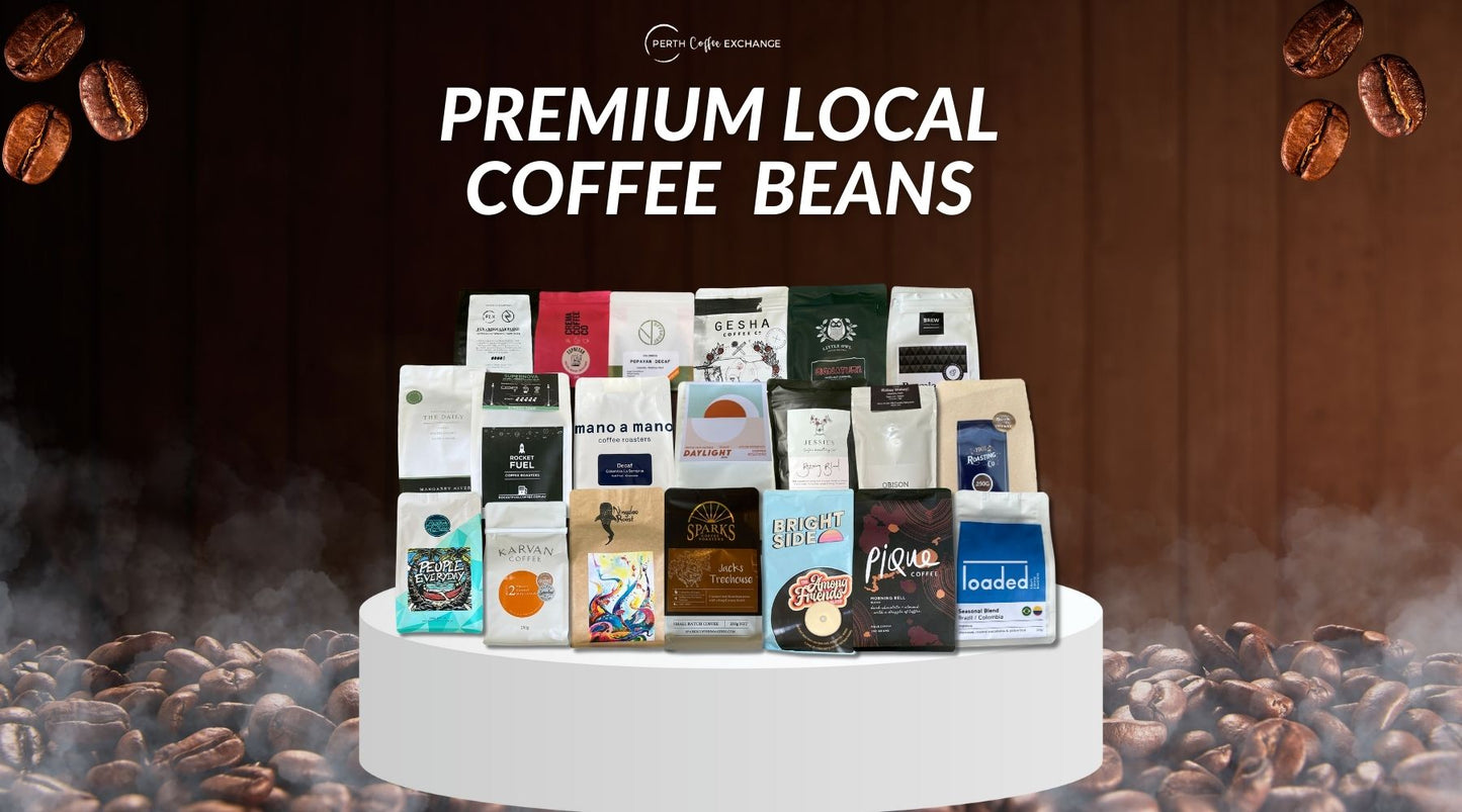 A display of various Perth Coffee Exchange brands of premium local coffee beans packaged in colorful bags, arranged on a white table against a dark background, with coffee beans floating in the air above.