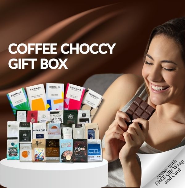 A woman of Perth smiles as she eats chocolate, next to a gift box filled with assorted coffee and chocolate products, labeled with "Coffee Choccy Gift Box". Text promoting a free cup and card offer is included.